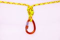 New red oval touristic and alpinistic carabine hangs from double figure eight 8 knot. Stretched colored, green rope for Royalty Free Stock Photo