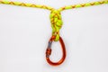 New red oval touristic and alpinistic carabine hangs from double figure eight 8 knot. Stretched colored, green rope for Royalty Free Stock Photo
