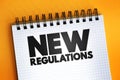 New Regulations text quote on notepad, concept background Royalty Free Stock Photo