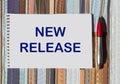 NEW RELEASE text on notepad with pen on vintage background Royalty Free Stock Photo