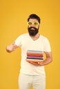 New releases. Happy student pointing finger at books pile. Bearded man pointing index finger yellow background. Pointing