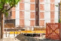 New residential building construction site entrance with gate of safety net fence with view on the concrete and metal reinforcemen Royalty Free Stock Photo