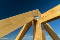New residential construction home framing and installation of wooden beams at the roof truss system of the house against a blue