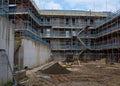 New residential multistorey appartment building made of brick and concrete block, with scaffolds erected around it to provide