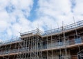 New residential multistorey appartment building made of brick and concrete block, with scaffolds erected around it to provide