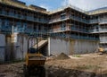 New residential multistorey appartment building made of brick and concrete block, with scaffolds erected around it to provide