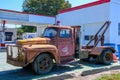 Rusted Antique Tow Truck in Front of a Retro Filling Station Royalty Free Stock Photo