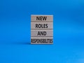 New roles and responsibilities symbol. Wooden blocks with words New roles and responsibilities. Beautiful blue background. Royalty Free Stock Photo