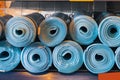 New rolled up yoga and fitness mats on a store shelf. Accessories or attributes for sports and a healthy lifestyle Royalty Free Stock Photo