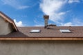 New roof with skylight, asphalt roofing shingles and chimney. Roof with mansard windows Royalty Free Stock Photo