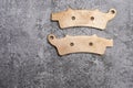 New rose gold colored metal motorcycle twin brake pads with ferodo on a gray surface Royalty Free Stock Photo