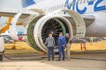 New Russian civil airliner airport technician and and business representatives looking into the engine. Russia, Moscow, 21 july