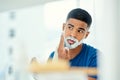 This new shaving foam smells great. a young man applying shaving foam to his face. Royalty Free Stock Photo