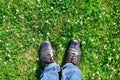 New shoes top view from above. Beautiful selfie feet walking on green grass background meadow flowers spring. Black sneaker top Royalty Free Stock Photo