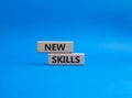 New skills symbol. Wooden blocks with words New skills. Beautiful blue background. Business and New skills concept. Copy space Royalty Free Stock Photo