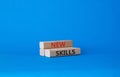 New skills symbol. Wooden blocks with words New skills. Beautiful blue background. Business and New skills concept. Copy space Royalty Free Stock Photo