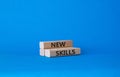 New skills symbol. Wooden blocks with words New skills. Beautiful blue background. Business and New skills concept. Copy space Royalty Free Stock Photo