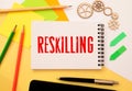 word Reskilling on white paper. Reskilling and upskilling development concept