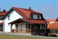 New small suburban family house with front wooden porch and brand new roof tiles surrounded with paved driveway and freshly cut Royalty Free Stock Photo