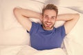 New smile, new day. Happy man awaken in bed. Handsome caucasian man with happy smile relaxing in the morning. Sparkling Royalty Free Stock Photo