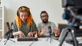 New Sound. Man and woman making music using synthesizer, drum pad machine, laptop. Female and male blogger recording Royalty Free Stock Photo