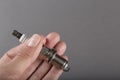 New spark plug in hand on a dark background