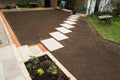 New stepping stone slabs along a landscaped garden with soil prepared ready for ne grass turf lawn to be installed Royalty Free Stock Photo
