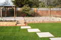 New stepping stones leading to steps and a raised patio with a wooden gazebo, next to a gravel stone planting area. Royalty Free Stock Photo