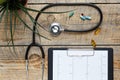 New stethoscope on wooden table with cardiogram top view