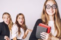 New student bookwarm in glasses against casual group on white, teen drama Royalty Free Stock Photo