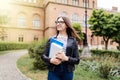 New study year begin. Female student holding notebooks outdoors and smiling on Uni background Royalty Free Stock Photo