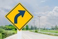 The new symbol reflective yellow right turn sign has a black arrow inside the frame located on the side of the country road. Royalty Free Stock Photo