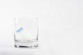 new tampon for critical days on a white background. feminine hygiene items. the swab in a glass beaker has absorbed a Royalty Free Stock Photo