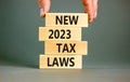 New 2023 tax laws symbol. Concept words New 2023 tax laws on wooden blocks. Beautiful grey table grey background. Businessman hand Royalty Free Stock Photo