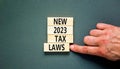 New 2023 tax laws symbol. Concept words New 2023 tax laws on wooden blocks. Beautiful grey table grey background. Businessman hand Royalty Free Stock Photo