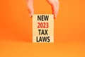 New 2023 tax laws symbol. Concept words New 2023 tax laws on wooden blocks. Beautiful orange table orange background. Businessman