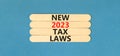 New 2023 tax laws symbol. Concept words New 2023 tax laws on wooden stick. Beautiful blue table blue background. Business new 2023