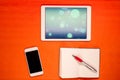 New technology on desk: mobile phone, open tablet, empty notebook and pen Royalty Free Stock Photo