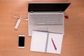 New technology on the desk: open laptop with charging power bank and memory stick connected, mobile phone and open notebook with Royalty Free Stock Photo