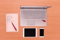 New technology on desk: open laptop with USB stick, mobile phone, tablet and closed notebook with red pen Royalty Free Stock Photo