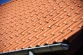 New tiled roof with sheet metal gutter and blue sky