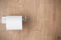 new toilet tissue on chrome holder at wood background