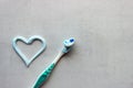 A new toothbrush and blue and white toothpaste in the shape of a heart.Tools for personal oral hygiene.