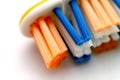 New toothbrush with yellow, blue and white bristles on the plastic base isolated on a white background. Shot in macro. Royalty Free Stock Photo