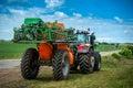 Tractor with trailed sprayer, near winter crop field, spring crop fertilizers, beautiful sky Royalty Free Stock Photo