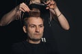 New trendy modern hairstyle. Barber is shearing man hair. Midle-aged man in barbershop. Professional hairdressed. Portrait of Royalty Free Stock Photo