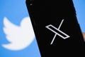 New Twitter logo X. Elon Musk change Twitter logo. Smartphone with Twitter logo on the screen