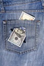 New U.S. hundred dollar bills put into circulation in October 2013 in the back pocket of jeans full of holes. The concept of Royalty Free Stock Photo