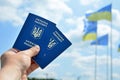 New ukrainian blue biometric passport with identification chip on against blue sky and waving flag background. Royalty Free Stock Photo