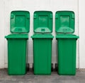 A new unbox green large bins ready to use on footpath and white concrete wall Royalty Free Stock Photo